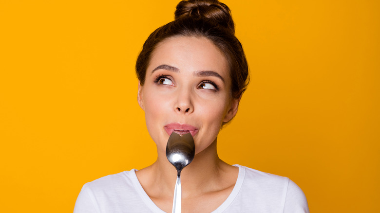 woman with spoon to mouth