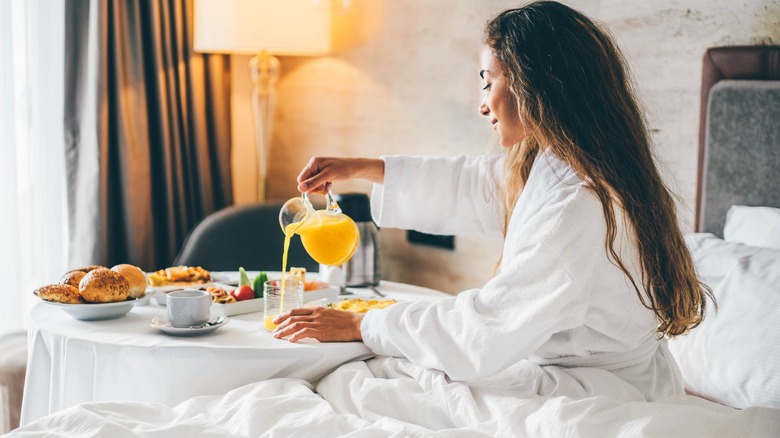 woman eating breakfast in a hotel bed