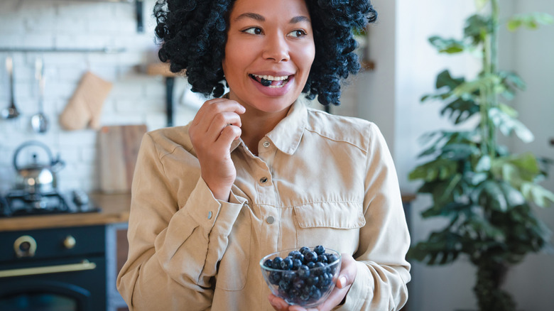 Woman eating blueberries from a bowl