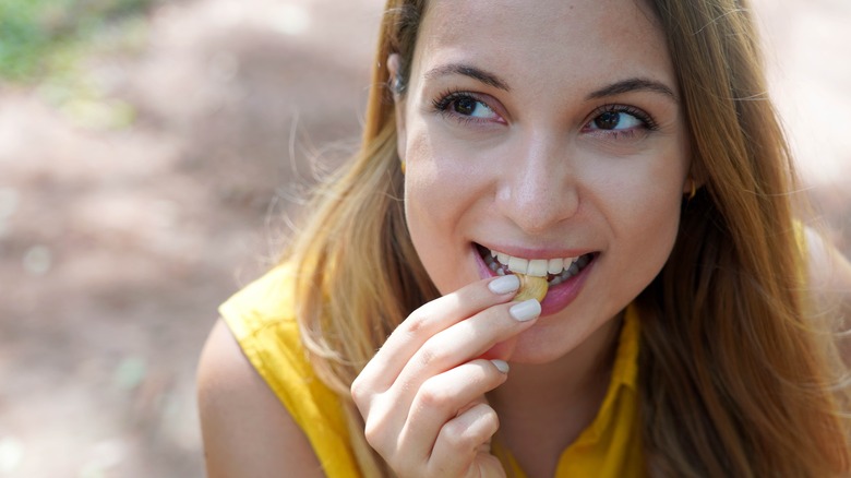 woman eating cashews outside