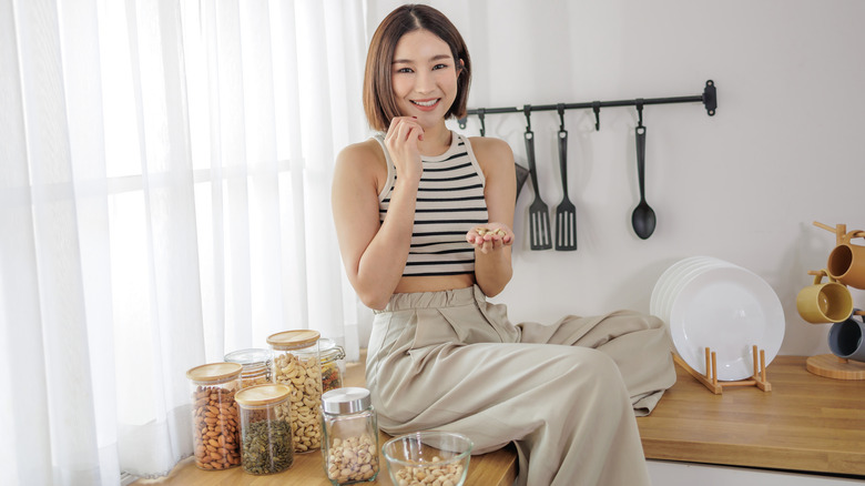 Smiling woman eating nuts