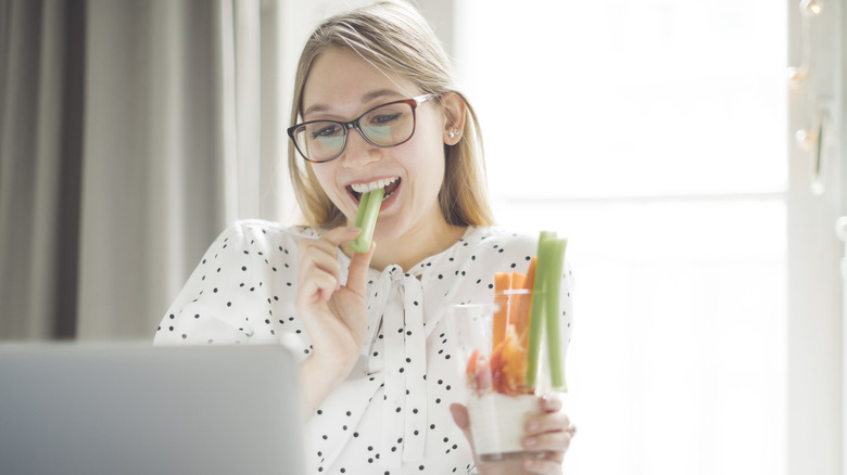 woman eating a stalk of celery
