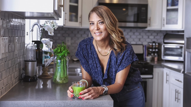 woman drinking a glass of celery juice