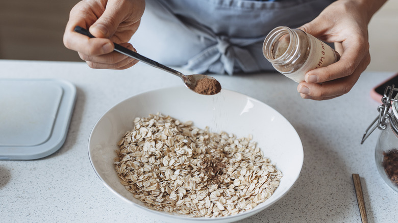 Woman adding cinnamon to oats