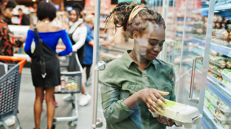 Smiling woman shopping for eggs