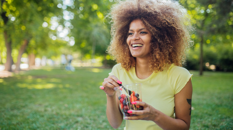 Woman eating fruit in park