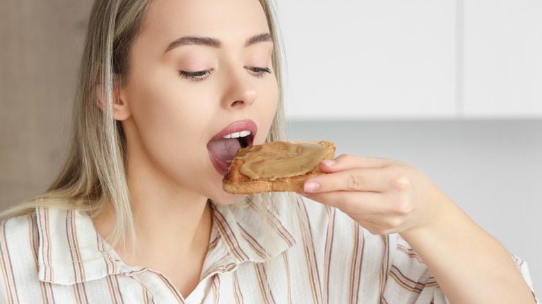Woman eating toast with peanut butter
