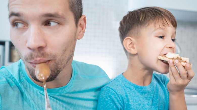 Father and son eating peanut butter