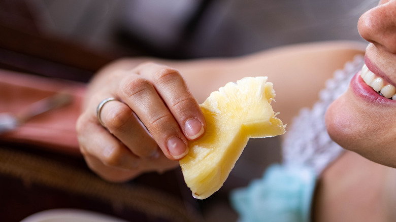 Woman eating pineapple