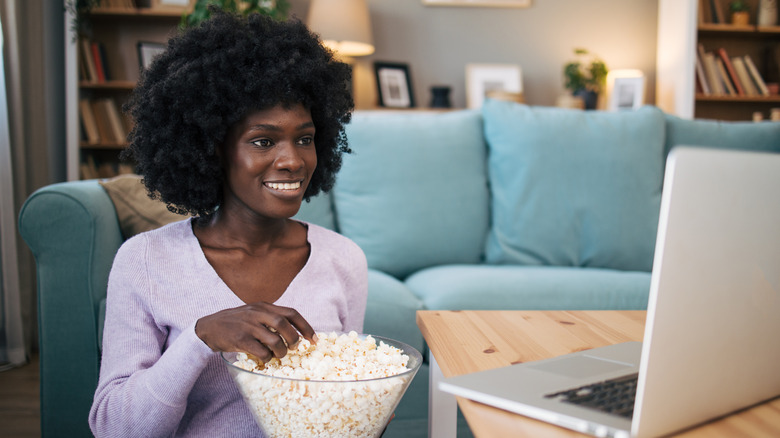 Smiling woman holding bowl of popcorn