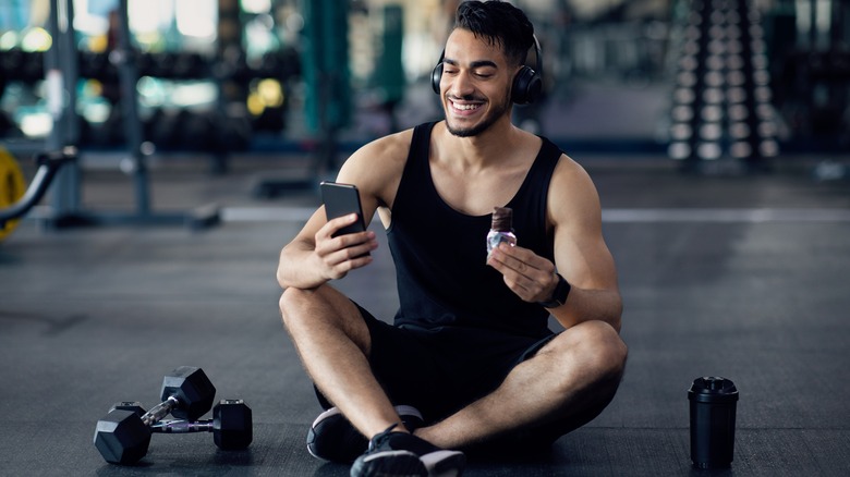 man at the gym eating a protein bar