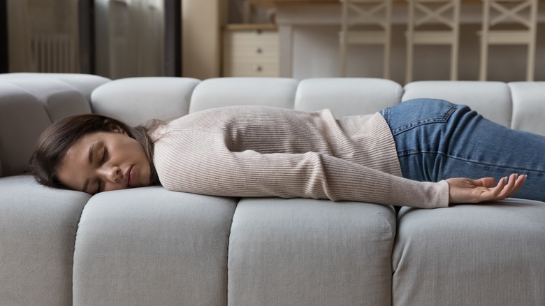 sleep-deprived woman laying on the couch