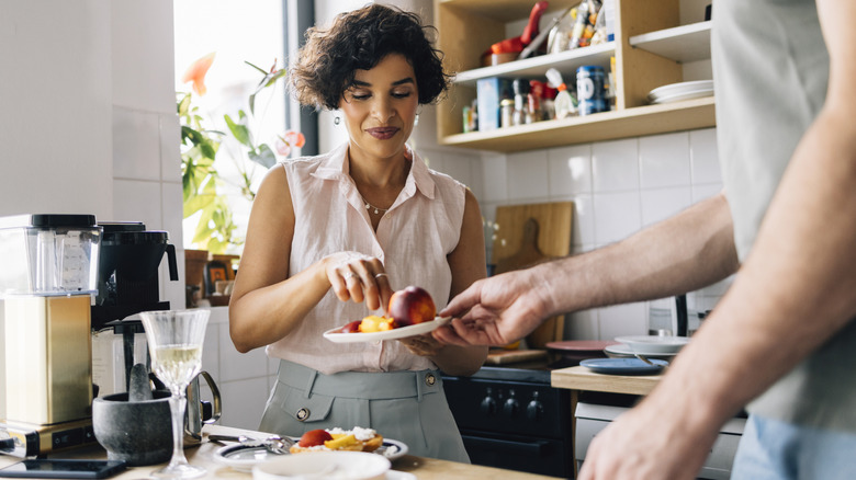 woman holding a plate of sliced peaches