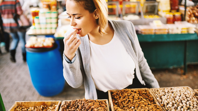 Woman eating nut at food market