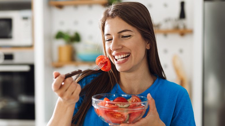 smiling woman eating tomatoes