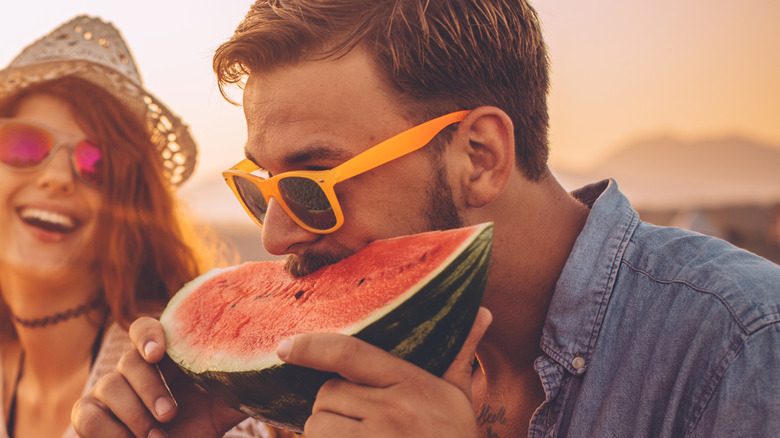 Man eating watermelon on beach