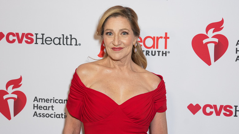 Edie Falco smiling in a red dress