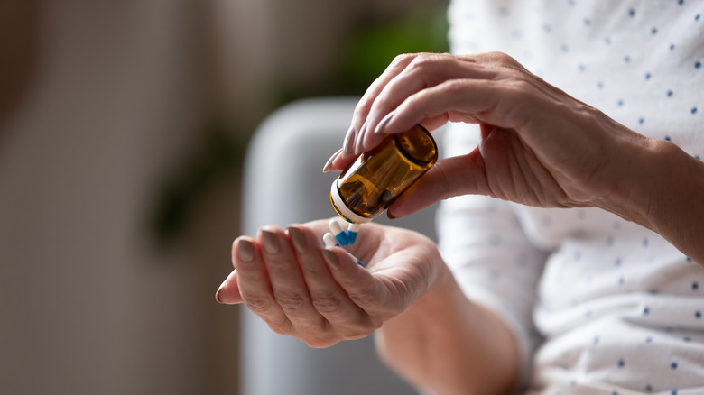 Person pours pills into their hand