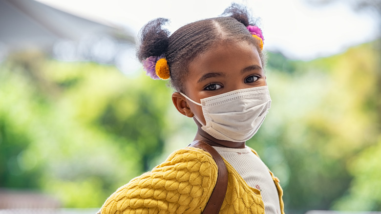 A small child wearing a mask