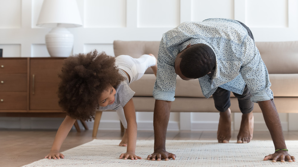 man and child doing pushups at home