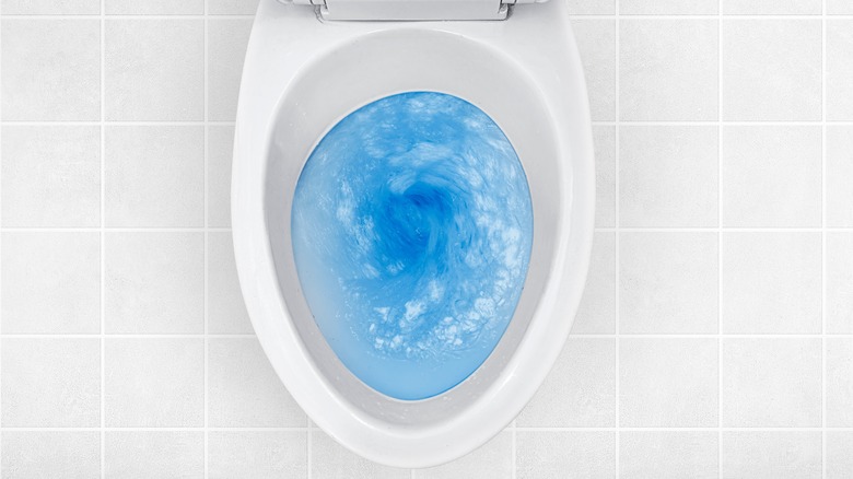 blue water swirling in toilet bowl