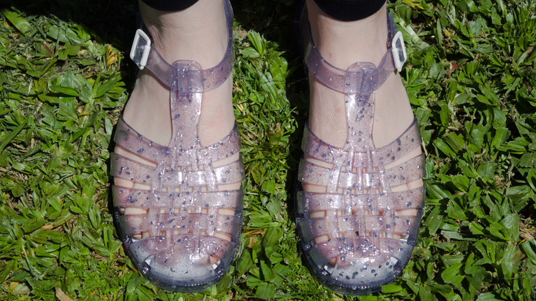 Woman modeling transparent plastic shoes also known as jellies