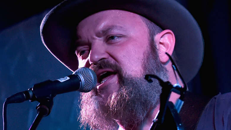 John Driskell Hopkins singing into microphone