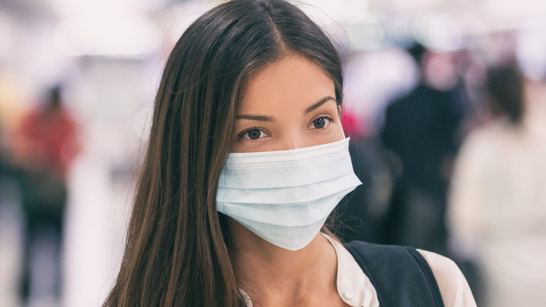 woman walking in crowd with mask