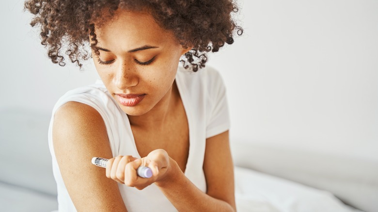 a woman injecting insulin into her arm 