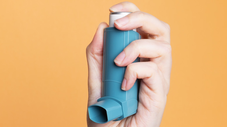 Hand holding an inhaler