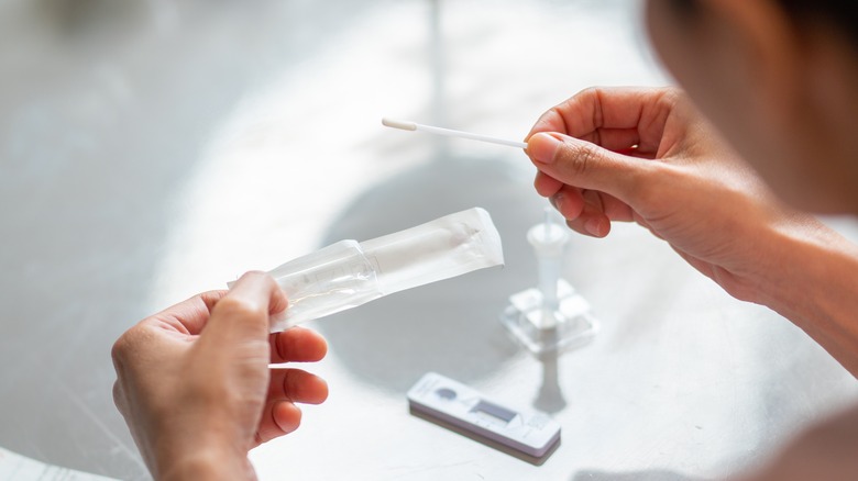 woman holding swab for COVID test