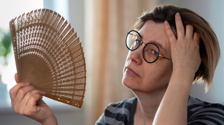 Middle-aged woman fanning self