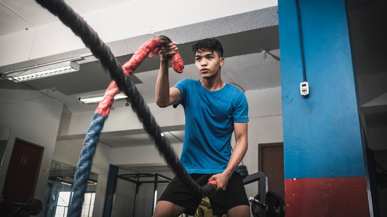 A man works out with weighted ropes