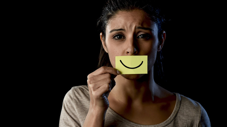 woman holding smiley post-it