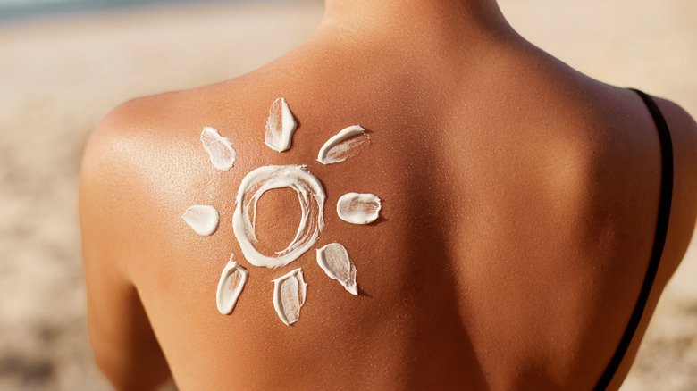 Sun drawn in sunscreen on a back