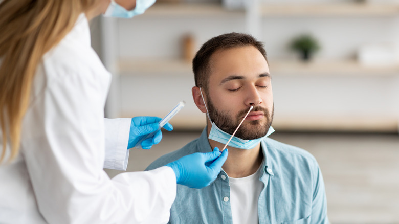 man getting COVID test with nose swab