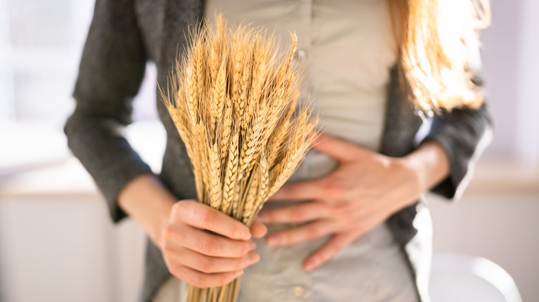 Person holding bundle of wheat