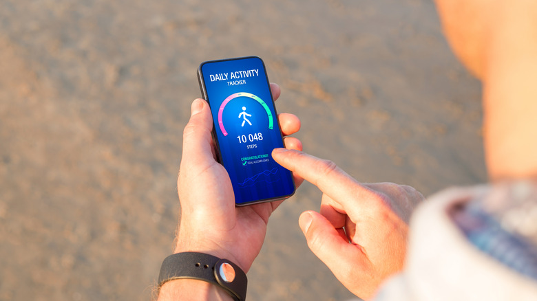Person holding phone with fitness app