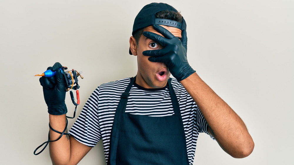 tattoo artist covering face