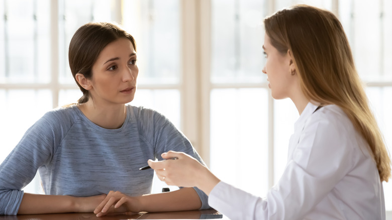 Young woman talking with doctor