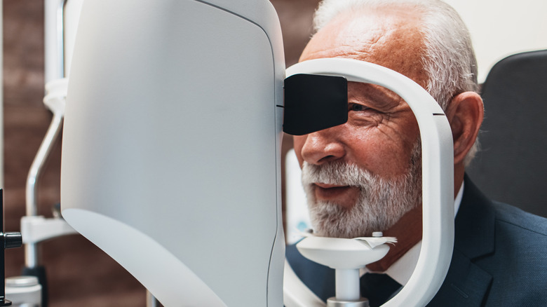 Senior man peering into tonometer