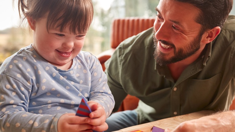 Man doing puzzle with Down syndrome girl