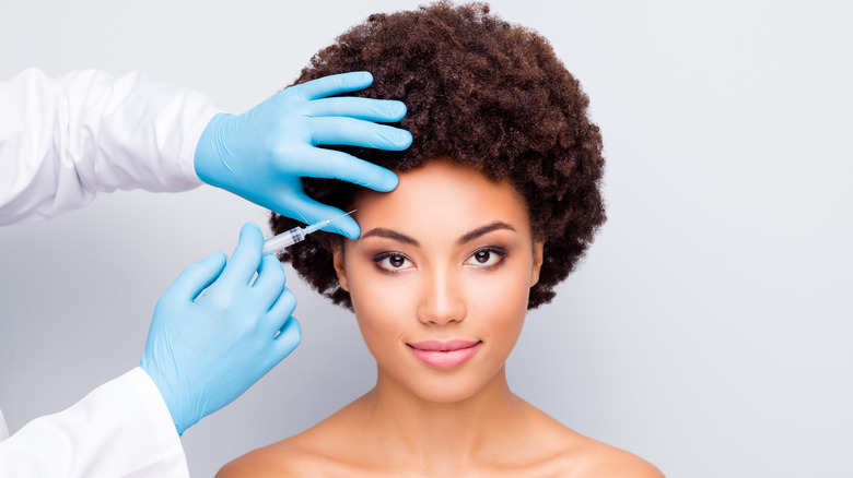 Woman pictured with a needle near her forehead