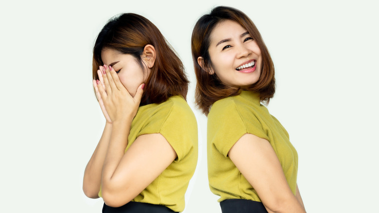 Young woman showing happy and sad faces