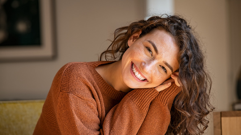 Woman in brown sweater smiling
