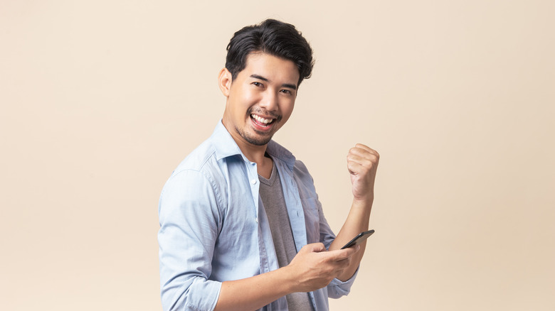Man smiling and holding phone