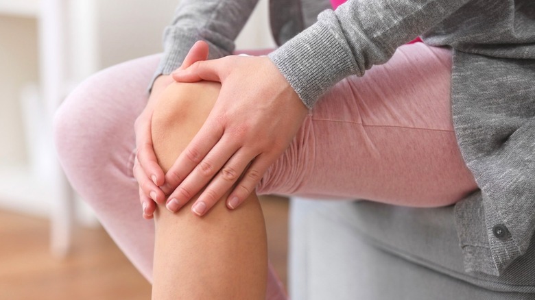 person holding pained knee