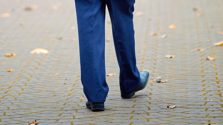 Person walking outdoors holding cane