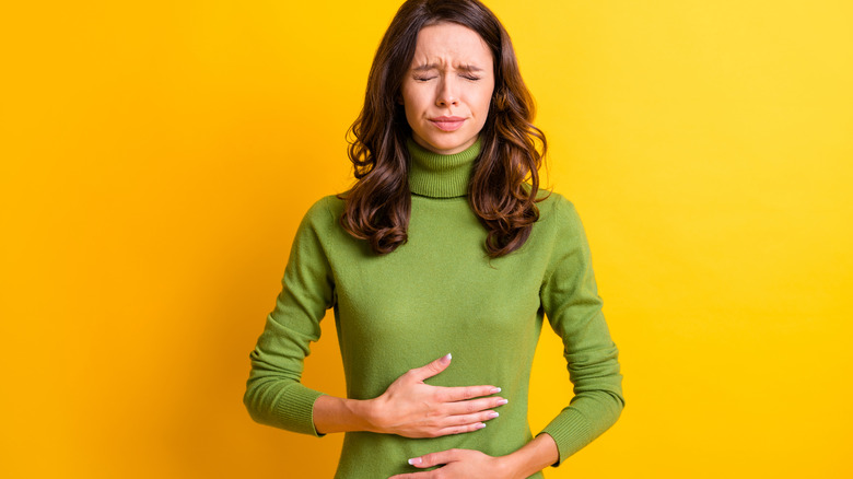 woman holding stomach in pain