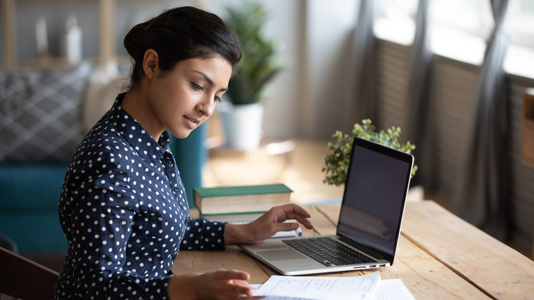 South Asian woman works at a desk